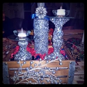 A set of candle holders and a bottle with a candle